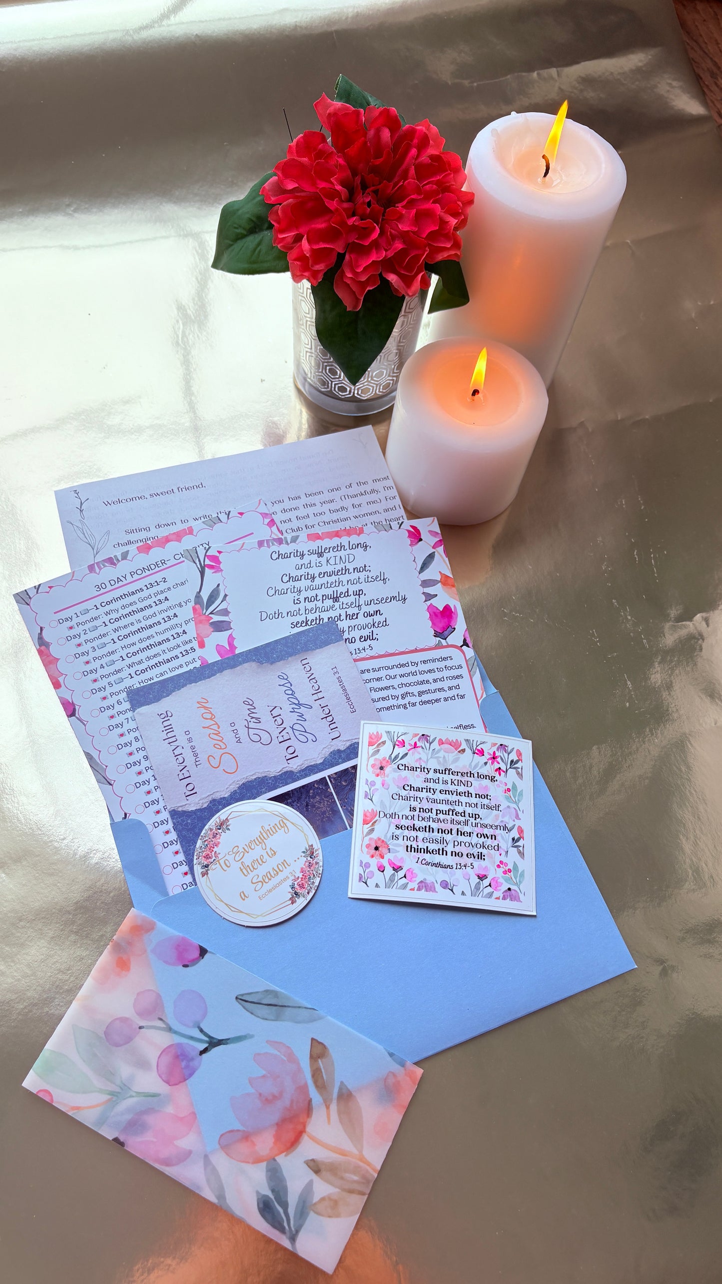 Candlelit scene with floral cards and a flower on a reflective surface